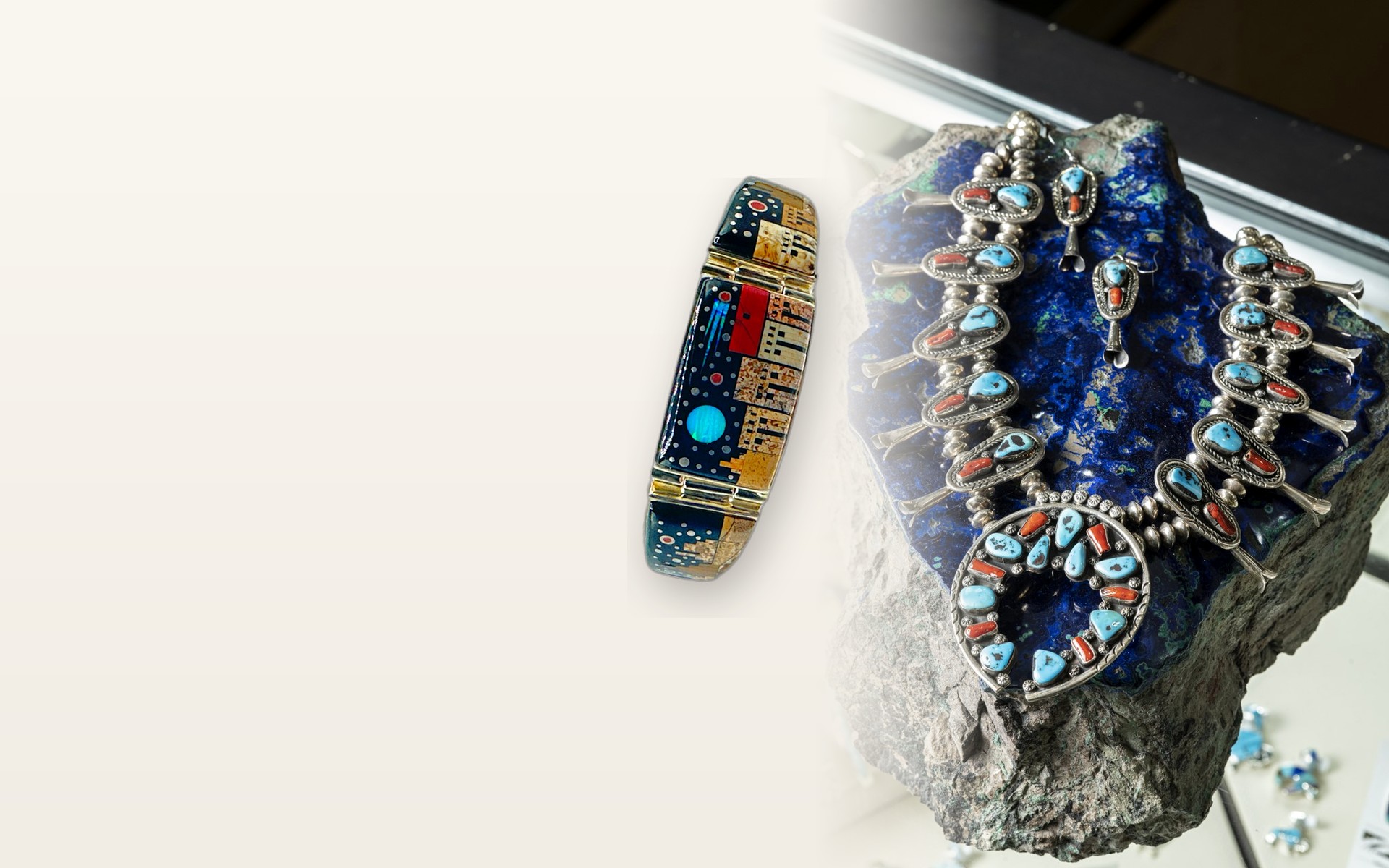 The original Sunrise squash blossom necklace on a rock beside an inlay bracelet